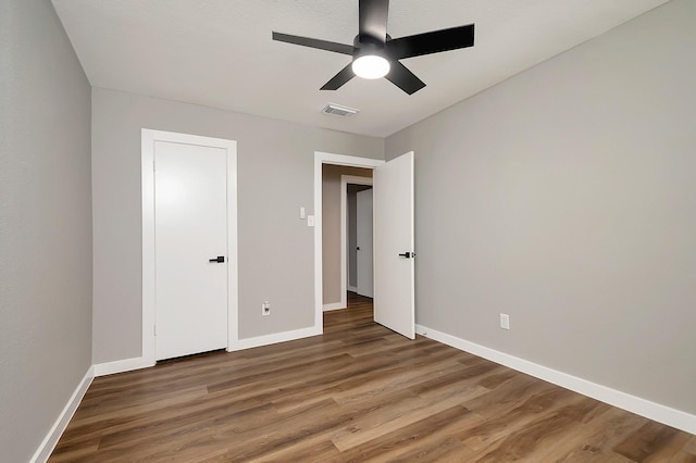 unfurnished bedroom with dark hardwood / wood-style flooring and ceiling fan