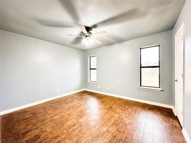 unfurnished room featuring hardwood / wood-style floors, ceiling fan, a textured ceiling, and a wealth of natural light