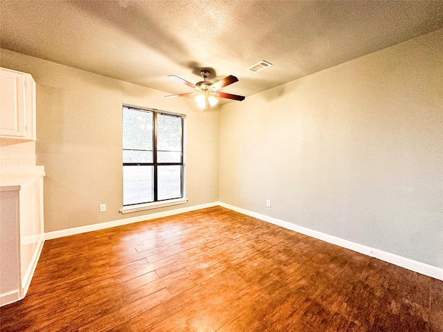 empty room featuring hardwood / wood-style floors, a textured ceiling, and ceiling fan