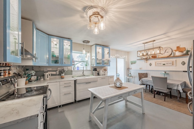 kitchen featuring white cabinetry, hanging light fixtures, and concrete floors