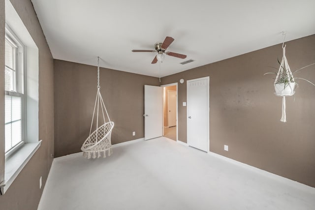 empty room featuring a wealth of natural light and ceiling fan