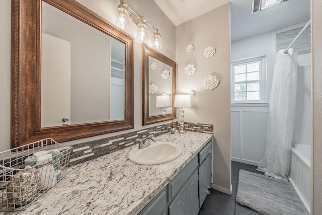 bathroom featuring shower / tub combo, vanity, and tasteful backsplash