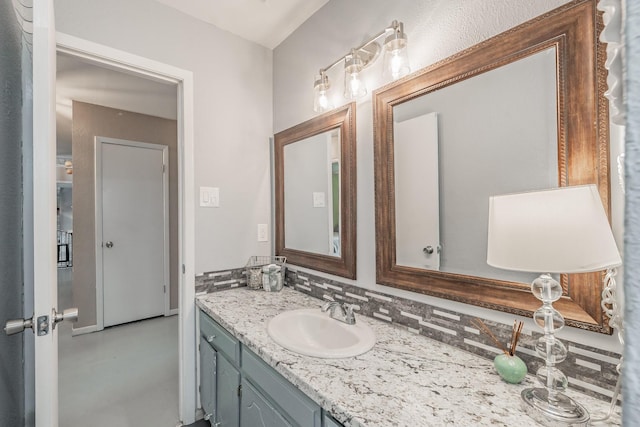 bathroom with vanity, decorative backsplash, and concrete floors