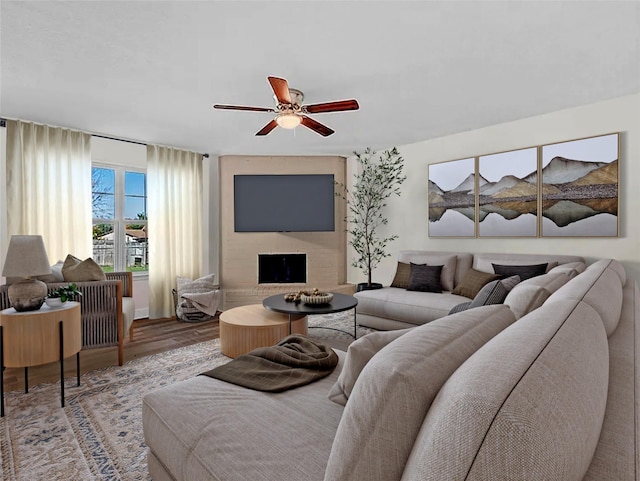 living room with hardwood / wood-style floors, ceiling fan, and a fireplace