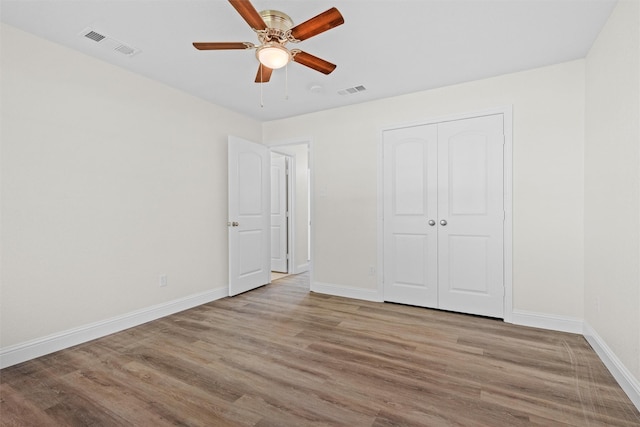 unfurnished bedroom featuring ceiling fan, light hardwood / wood-style flooring, and a closet