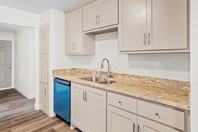 kitchen with sink, light hardwood / wood-style flooring, light stone countertops, and dishwashing machine