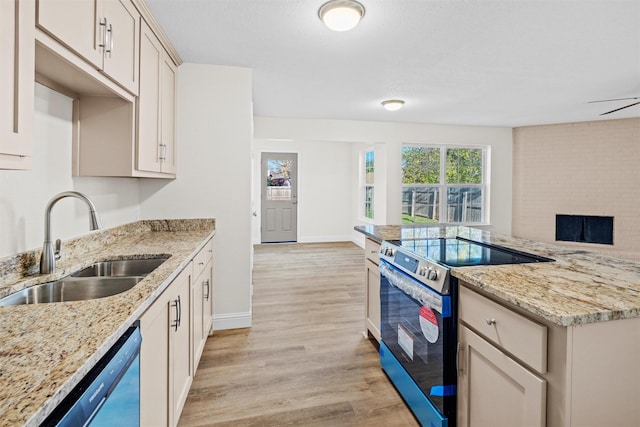 kitchen featuring stainless steel electric range, light stone counters, dishwashing machine, light hardwood / wood-style floors, and sink