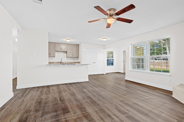 unfurnished living room featuring ceiling fan, dark wood-type flooring, and sink