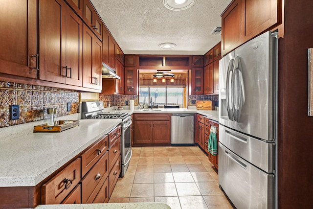 kitchen with a textured ceiling, stainless steel appliances, extractor fan, sink, and light tile patterned flooring