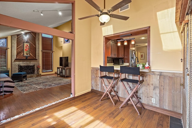 interior space with hardwood / wood-style floors, ceiling fan, a fireplace, and a textured ceiling