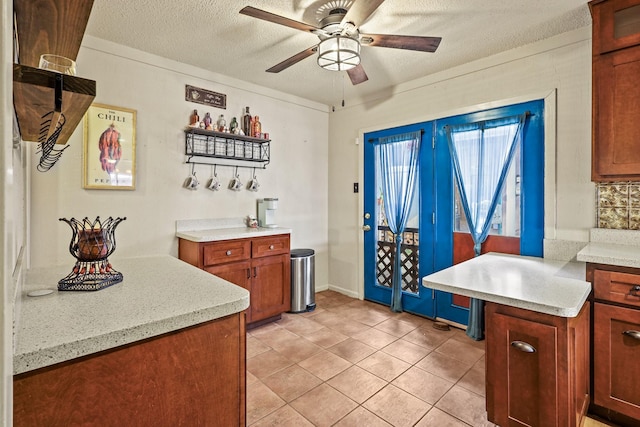 kitchen featuring ceiling fan, light tile patterned flooring, and a textured ceiling