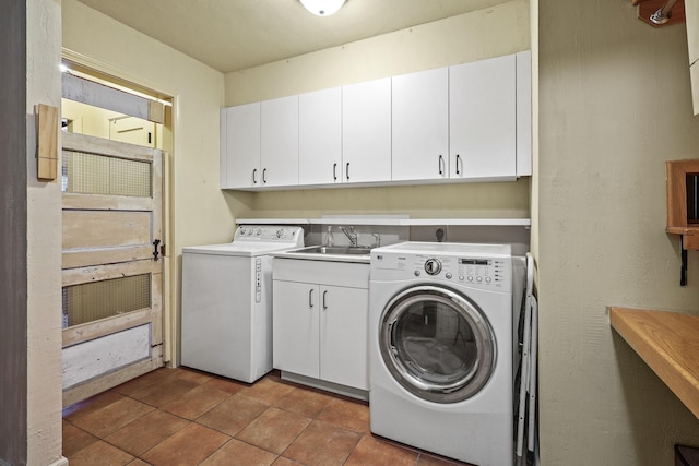 laundry room featuring light tile patterned flooring, cabinets, sink, and washing machine and clothes dryer