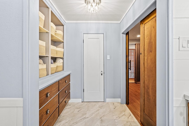 hall featuring an inviting chandelier and crown molding