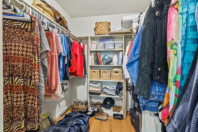 walk in closet with hardwood / wood-style floors