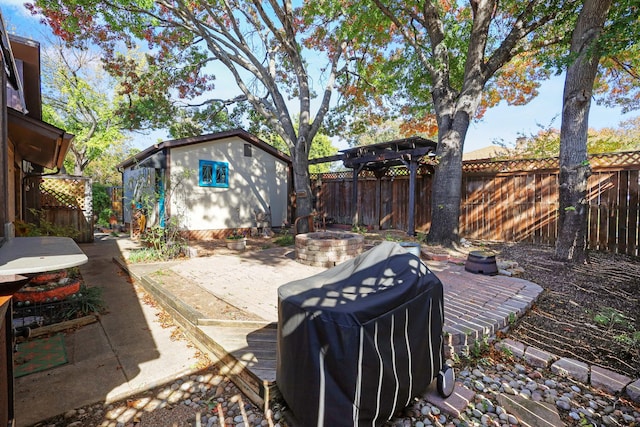 view of patio featuring an outbuilding and an outdoor fire pit