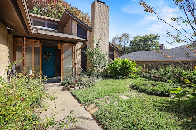 view of exterior entry with a lawn