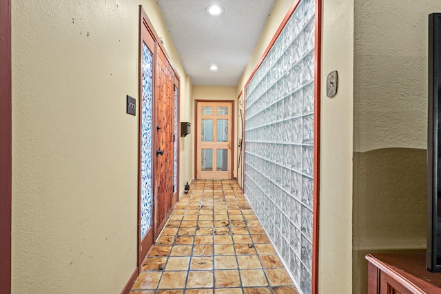 hall featuring a textured ceiling