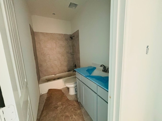 full bathroom featuring tiled shower / bath combo, vanity, and toilet