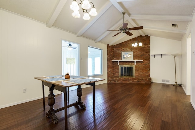 dining area featuring vaulted ceiling with beams, ceiling fan with notable chandelier, dark hardwood / wood-style floors, and a brick fireplace