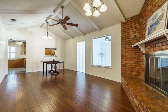 unfurnished living room featuring ceiling fan with notable chandelier, vaulted ceiling with beams, a brick fireplace, and dark hardwood / wood-style flooring