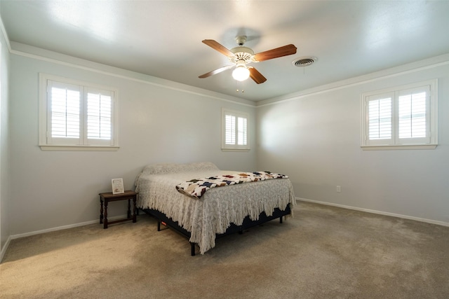 carpeted bedroom with crown molding and ceiling fan