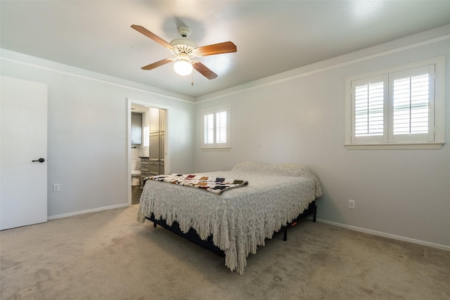 carpeted bedroom featuring multiple windows, connected bathroom, ceiling fan, and ornamental molding