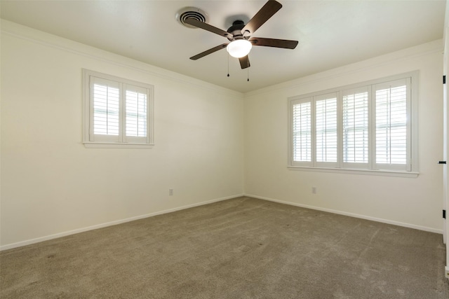 carpeted empty room featuring ceiling fan, crown molding, and plenty of natural light