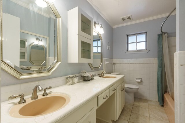 full bathroom featuring toilet, crown molding, shower / bath combo with shower curtain, tile walls, and tile patterned floors