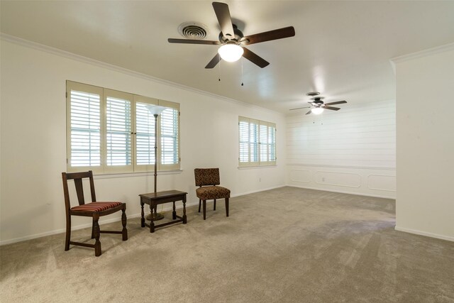 sitting room featuring light carpet, ceiling fan, and ornamental molding