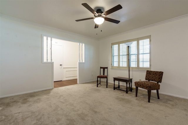 living area featuring ceiling fan, ornamental molding, and light carpet