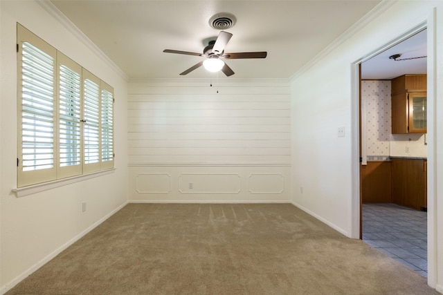 carpeted empty room featuring ceiling fan and ornamental molding