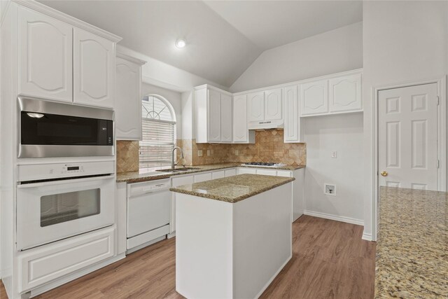 kitchen featuring white cabinets, a kitchen island, lofted ceiling, and appliances with stainless steel finishes