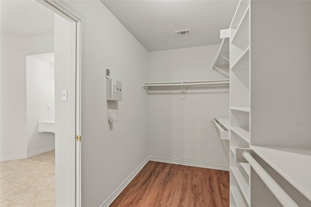 walk in closet with hardwood / wood-style floors