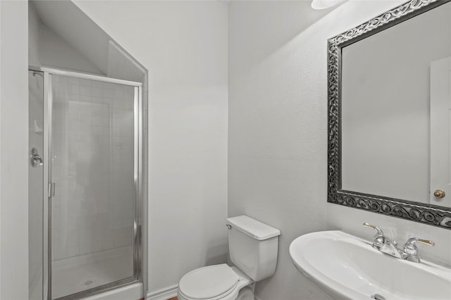 bathroom featuring sink, a shower with shower door, and toilet