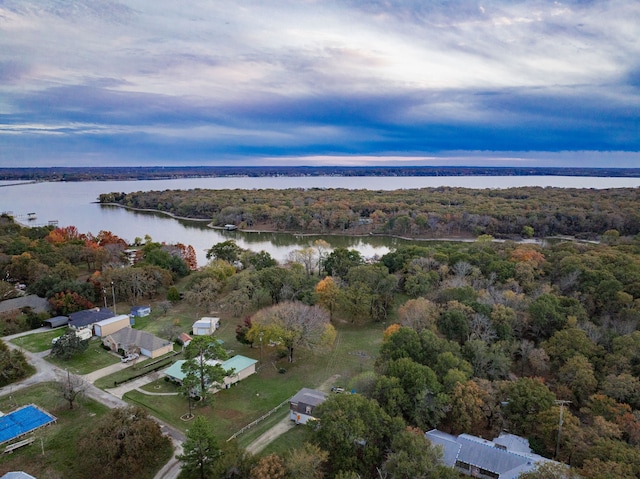 aerial view at dusk featuring a water view