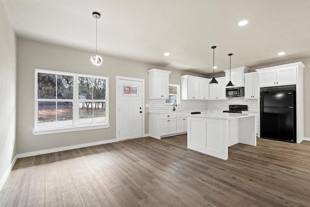 kitchen with a kitchen island, decorative light fixtures, tasteful backsplash, white cabinetry, and black appliances