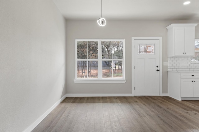 unfurnished dining area with light wood-type flooring