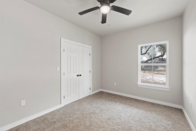 carpeted spare room featuring ceiling fan