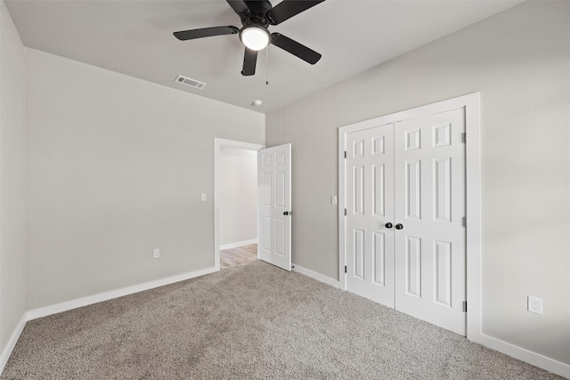 unfurnished bedroom with ceiling fan, carpet flooring, and a closet