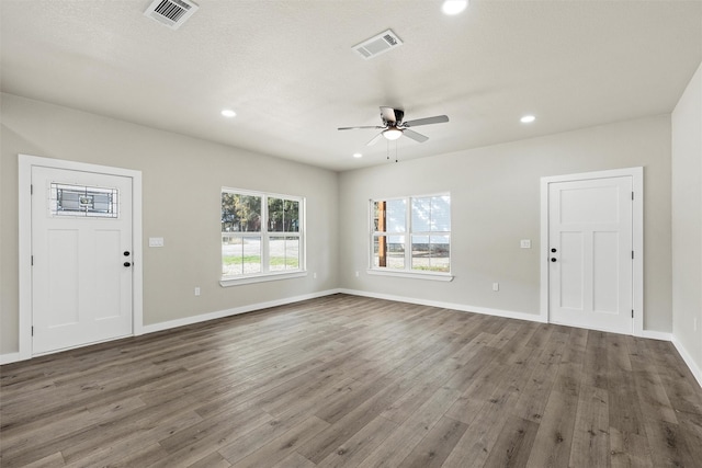 unfurnished living room with ceiling fan and dark hardwood / wood-style flooring