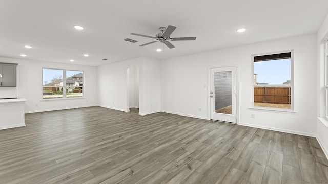 unfurnished living room with wood-type flooring and ceiling fan