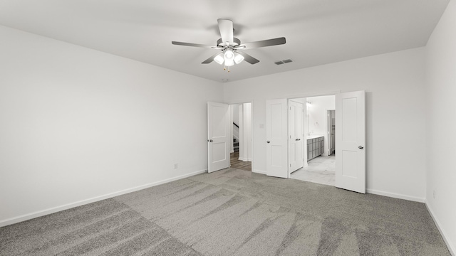 unfurnished bedroom with ceiling fan, light carpet, and ensuite bath