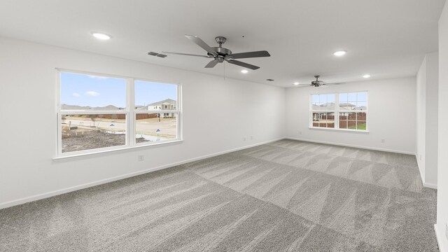 carpeted spare room featuring ceiling fan