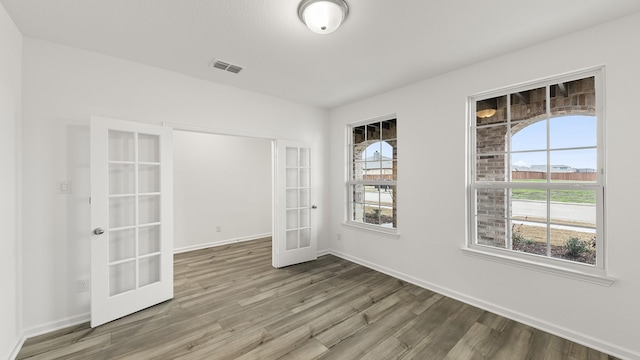 spare room featuring french doors and hardwood / wood-style floors