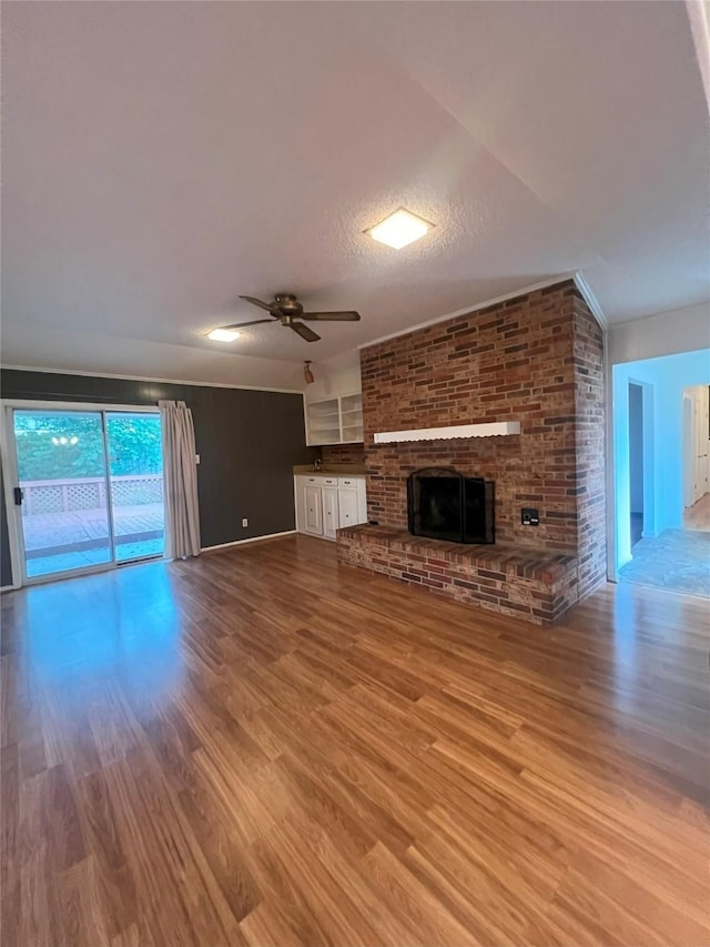 unfurnished living room with hardwood / wood-style floors, a textured ceiling, a fireplace, and ceiling fan