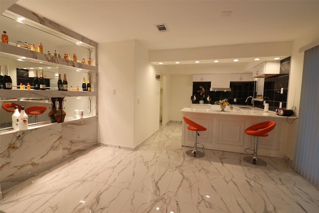 interior space with white cabinetry and sink