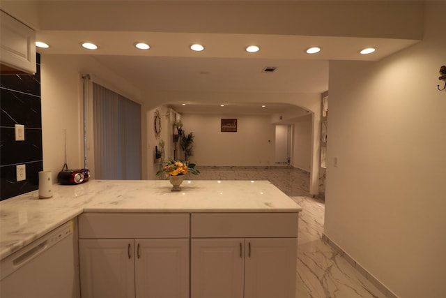 kitchen featuring kitchen peninsula, white cabinetry, white dishwasher, and light stone counters