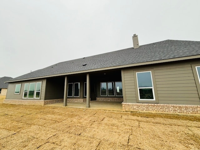 back of property featuring a yard and a patio area