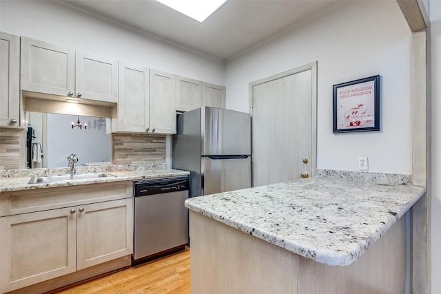 kitchen with sink, kitchen peninsula, stainless steel appliances, and light wood-type flooring