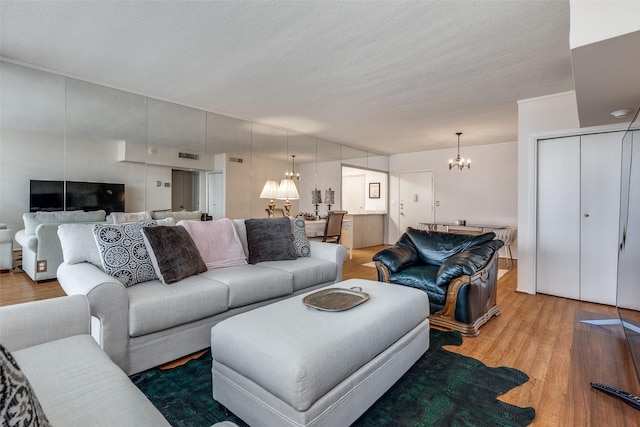 living room featuring hardwood / wood-style floors, a notable chandelier, and a textured ceiling